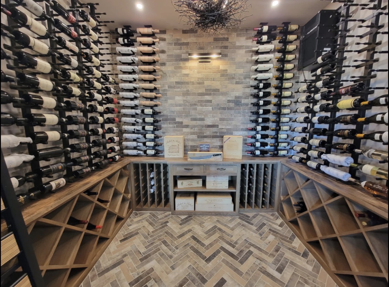 Completed wine room with custom timber storage, wall-mounted wine racks and herringbone tile
